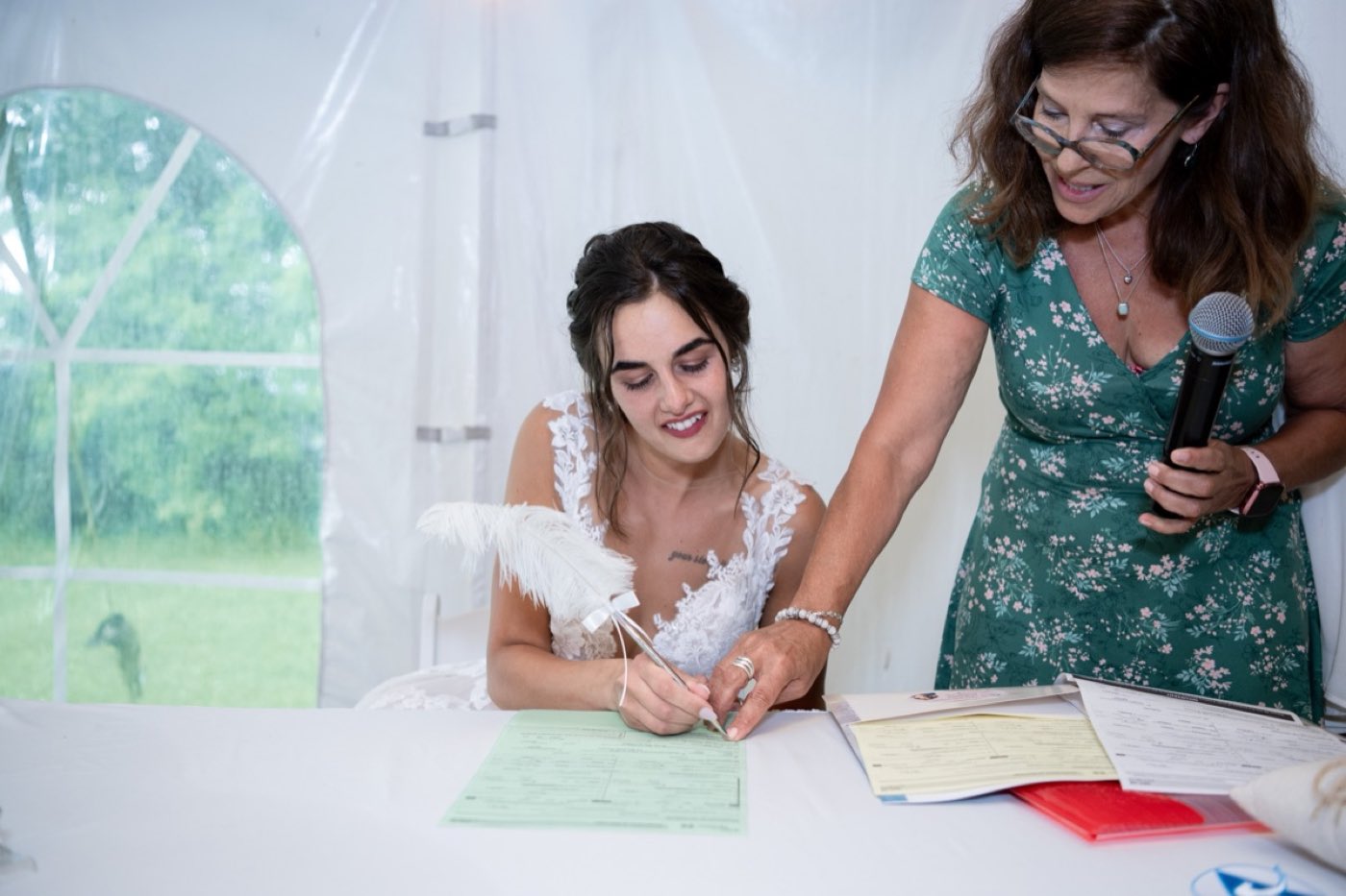 La mariée signe le registre à la plume, accompagnée d’Isabelle Ferland.